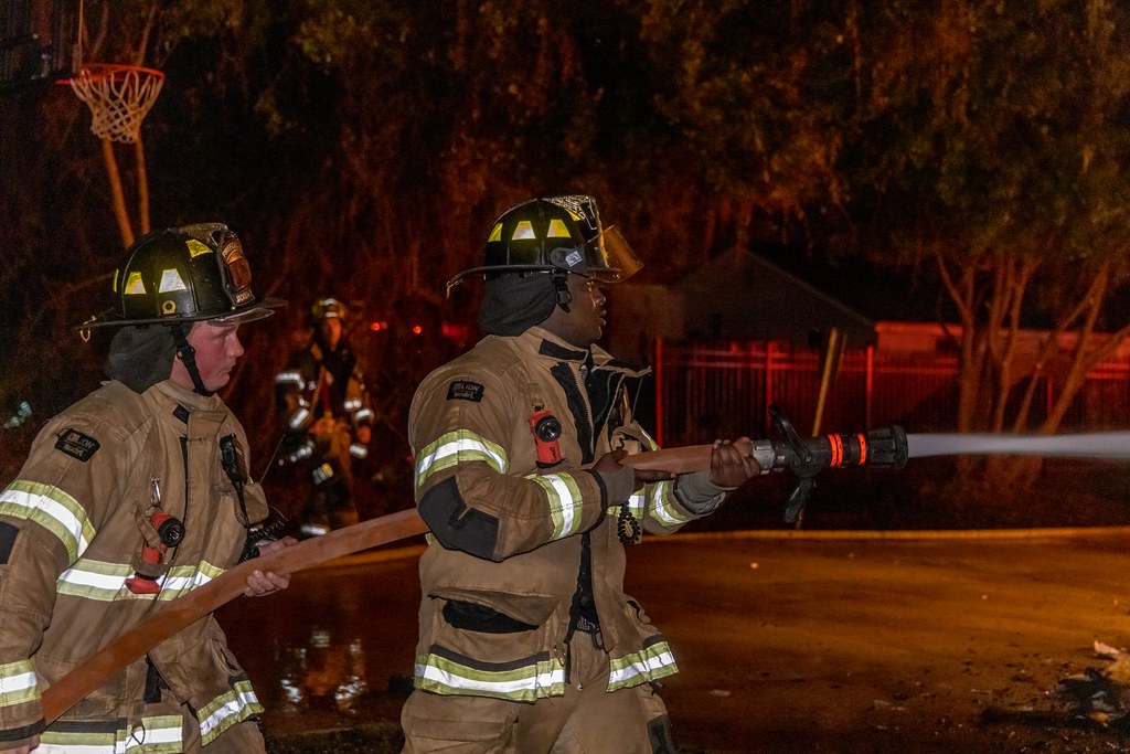 Firefighters using a hose to fight a fire