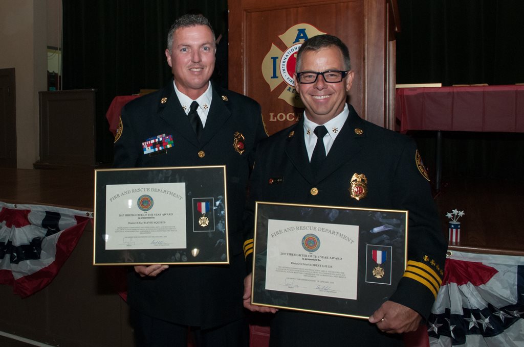 Two firefighters with their awards